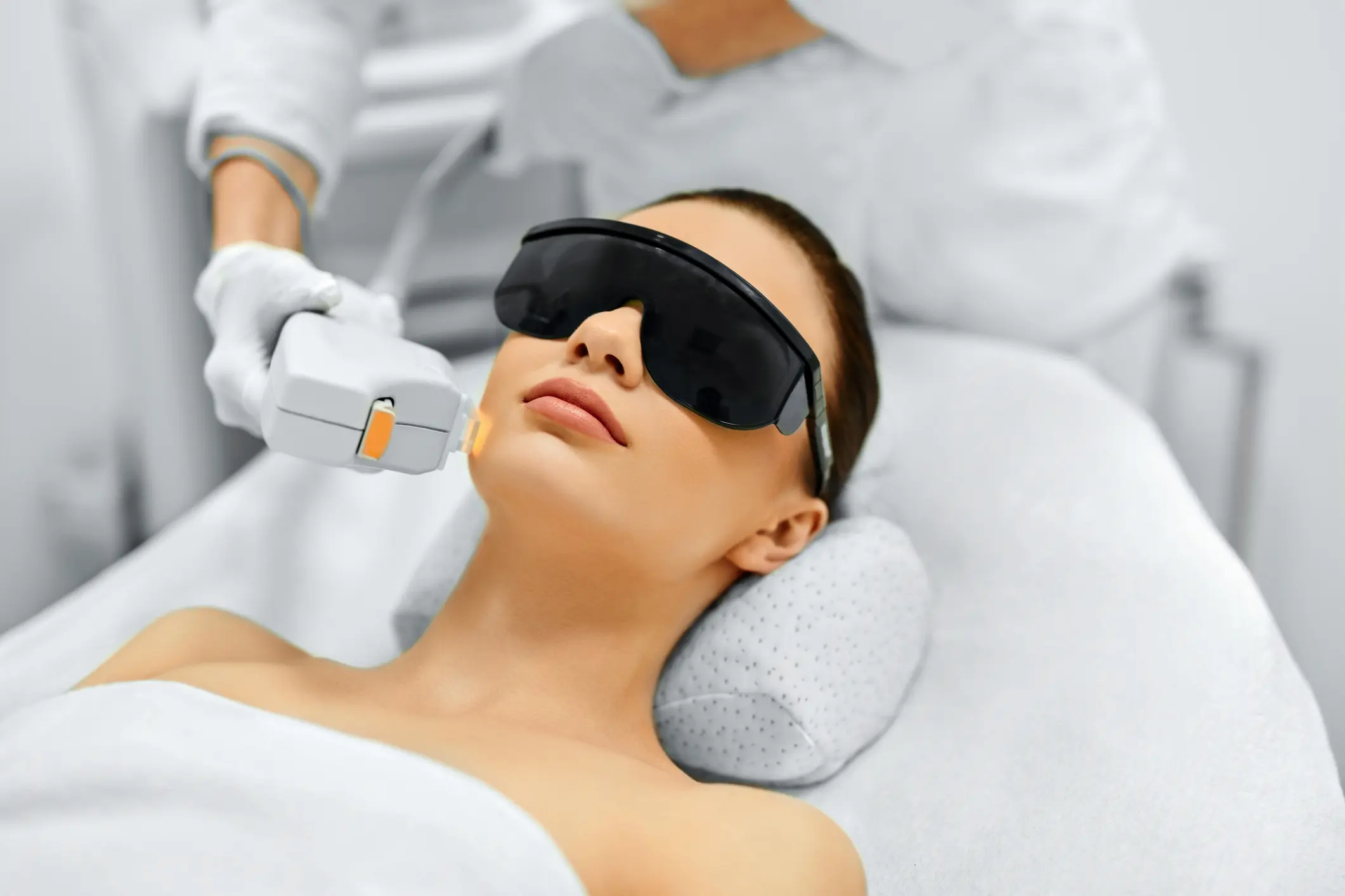 Woman receiving laser treatment wearing protective eyewear.